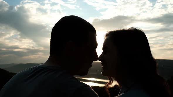 Young Couple Kissing Noses and Smiling at Sunset