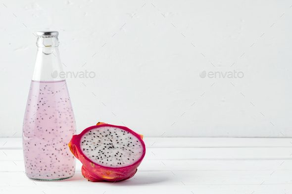 Glass bottle of dragon fruit drink on white background