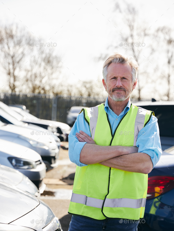 Portrait Of Mature Male Car Park Attendant Wearing Hi-Vis Safety Vest