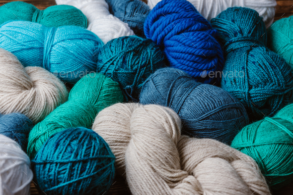 close up view of white, blue and green yarn for knitting as backdrop - Stock Photo - Images