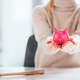 cropped shot of woman holding pink piggy bank - PhotoDune Item for Sale