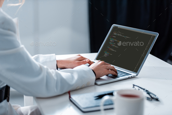 cropped view of woman using laptop with microsoft windows on screen at office desk - Stock Photo - Images