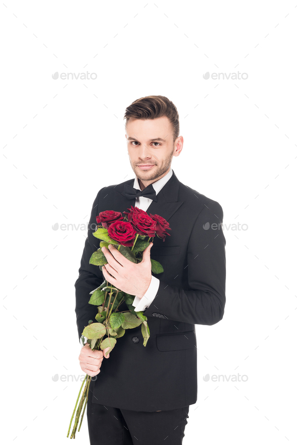 handsome elegant man in black suit holding red roses for valentines day