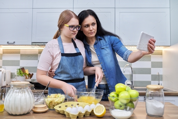 Mom and teenage daughter preparing apple pie together