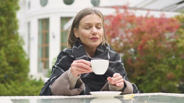 Woman in Plaid Drinking Warm Tea, Enjoying Autumn Morning in Yard, Comfort alt