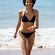 Happy black woman laughing while walking in bikini on the sand of the beach. - PhotoDune Item for Sale