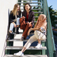 Company of smiling girls sitting on stairs and talking - PhotoDune Item for Sale