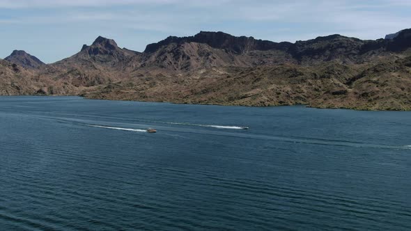 High-res 4K drone footage shows two fast boats racing full speed across lake Havasu in the summer ha alt
