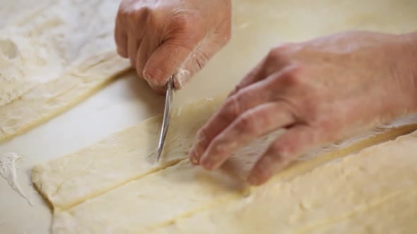 A Woman Prepares A Dough And Cuts It Into Various Shapes With A Knife