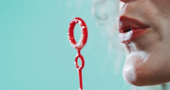 Close up of a girl blowing bubbles while dancing alt