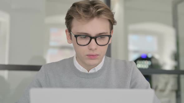 Close Up of Young Man Shaking Head As No Sign While Using Laptop alt