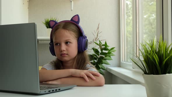 Little Girl is Using a Laptop and Study Online at Home alt