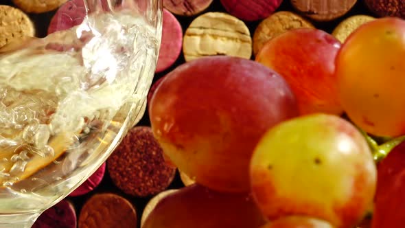 Pouring wine into a glass against the background of wine corks.	 alt