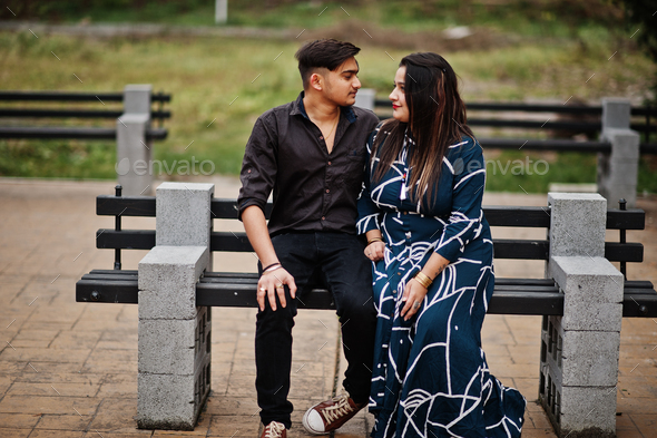 Love story of indian couple posed outdoor, sitting on bench together.  10441998 Stock Photo at Vecteezy
