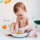 Baby eating by himself learning through the Baby-led Weaning method - PhotoDune Item for Sale