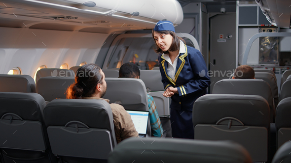 Female stewardess asking passengers about airline services