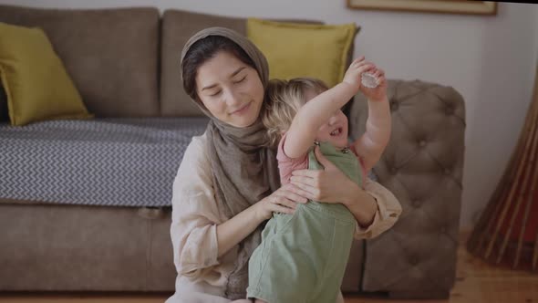 Adorable Infant Baby Boy Daughter Playing with Arabic Muslim Mom in Hijab at Home alt