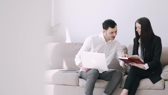 A Handsome Official Man and a Pretty Girl Are Reading Something in Notebooks
