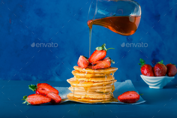 Syrup or honey is pouring to pancake stacks. Includes copy space. - Stock Photo - Images
