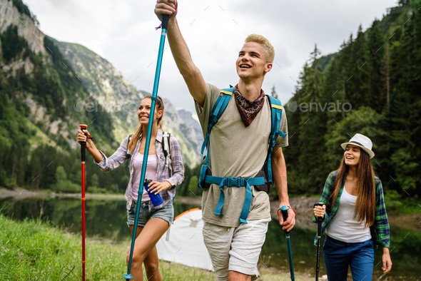 Group of young friends hiking in countryside. Multiracial happy