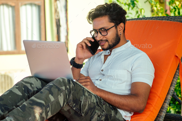 stylish young indian male freelancer working with laptop freelance