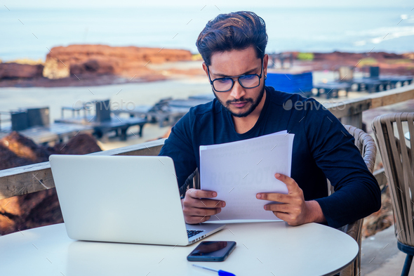 stylish young indian male freelancer working with laptop freelance