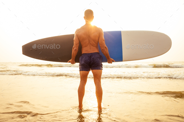 surfing freelancing man muscle and press sport training on the beach at sunset