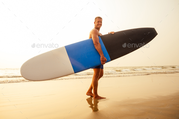 surfing freelancing man muscle and press sport training on the beach at sunset