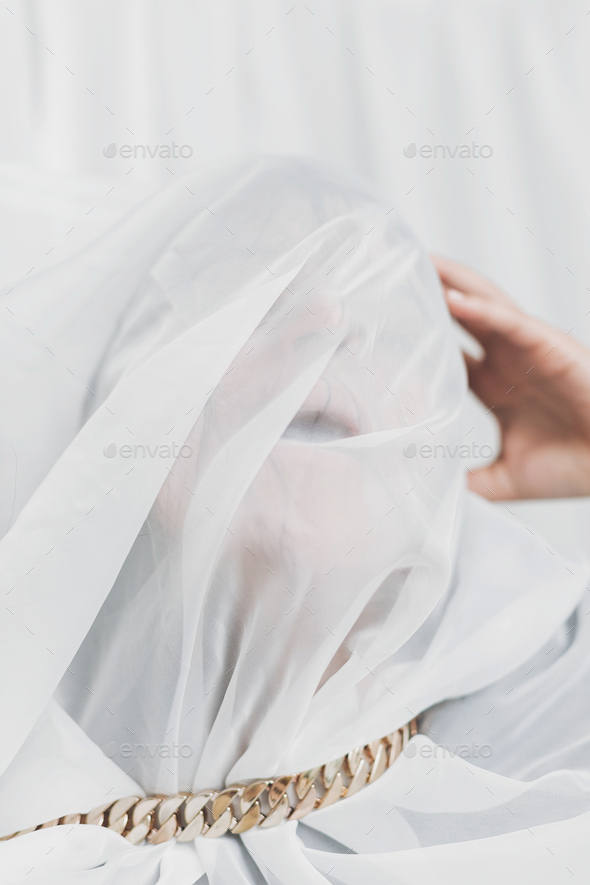 Social isolation and pressure. Woman suffocate under veil, posing with golden necklace. Mental break