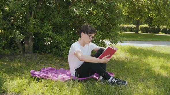 Young Man Reading the Book in the Park  alt
