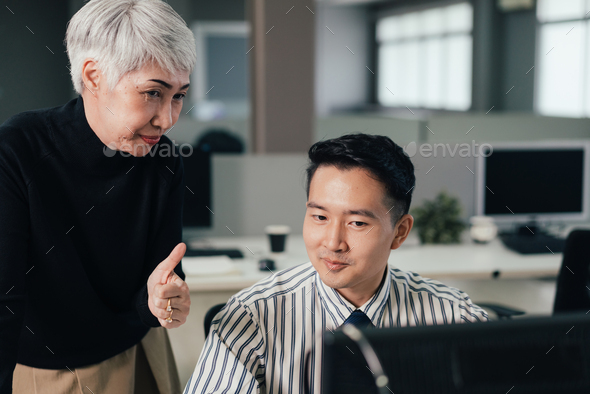 senior-female-manager-showing-thumb-up-to-praise-employee-performance