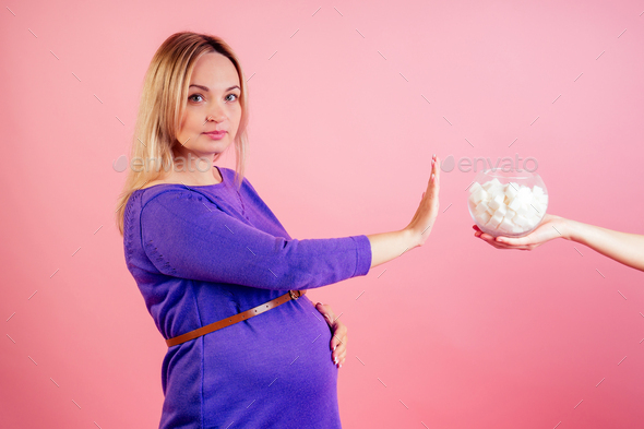 Stop eating sweets. Beautiful blonde pregnant woman in a violet dress