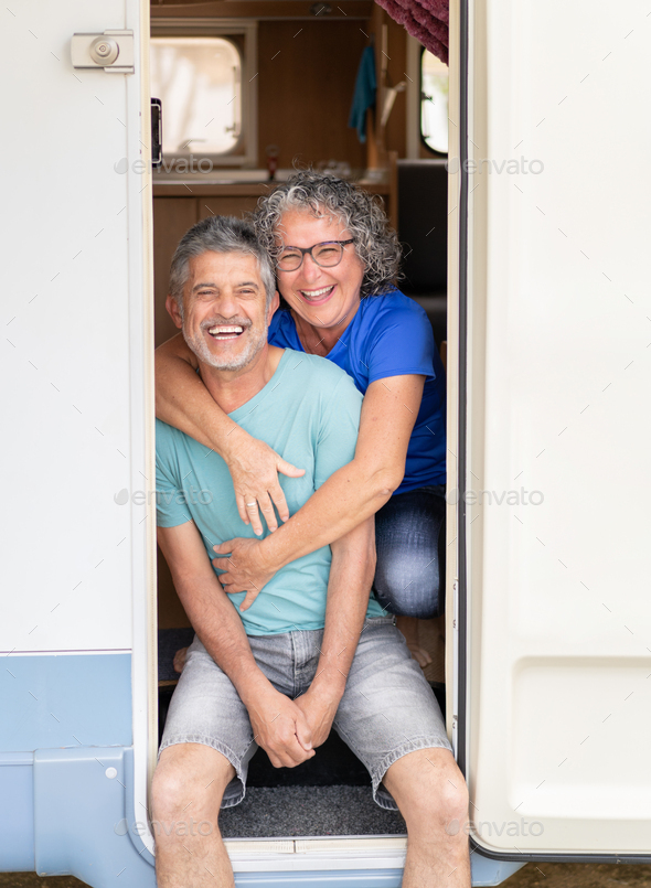 vertical portrait of an older couple with gray hair laughing and ...