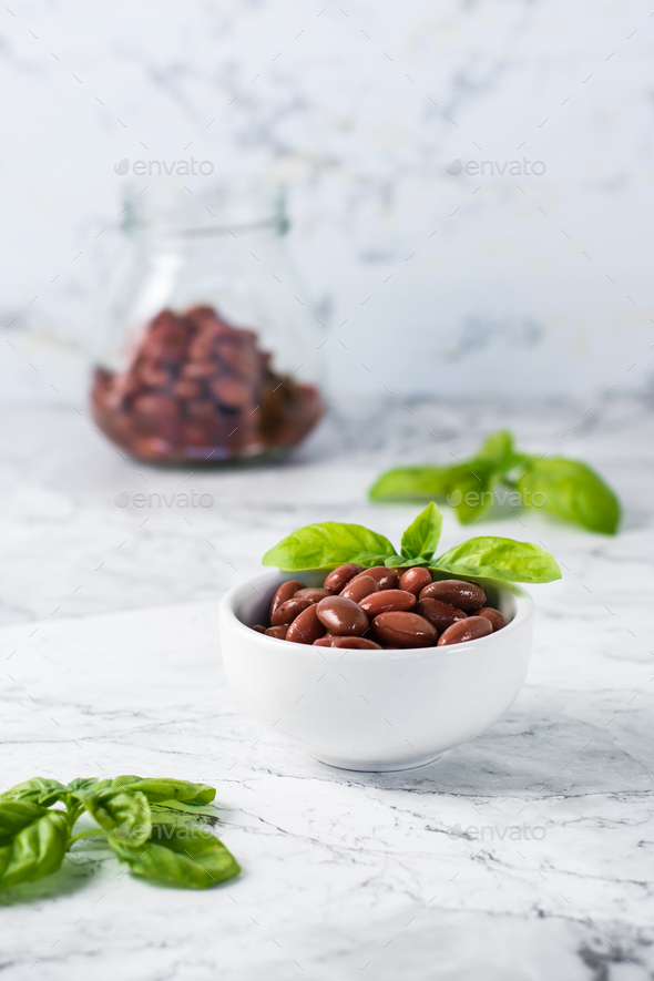 Boiled red beans in a bowl and jar and basil leaves. Meat protein