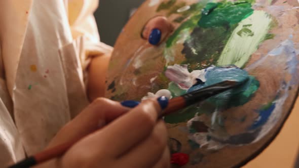 Art Studio  Woman Artist Mixing Colors on Palette alt