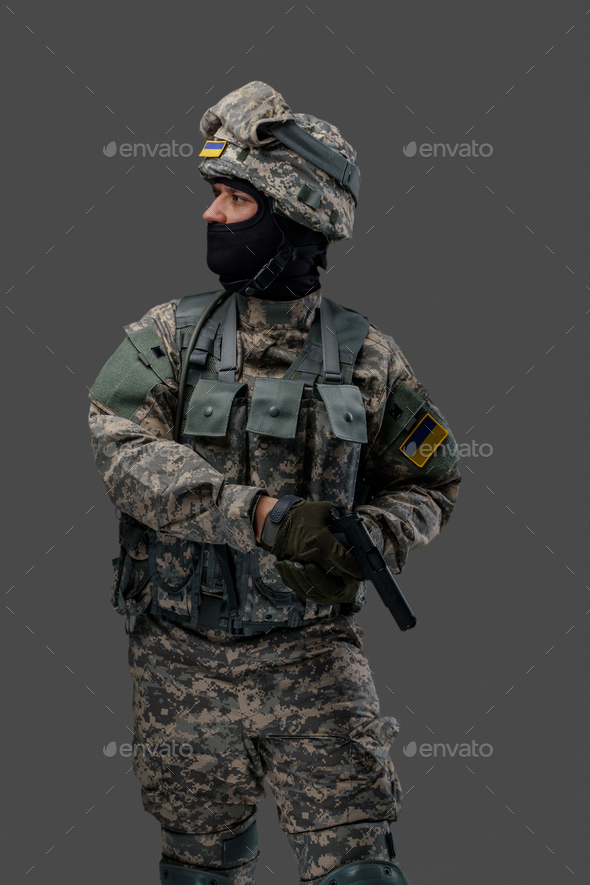 Ukrainian army man with firearm pistol looking away