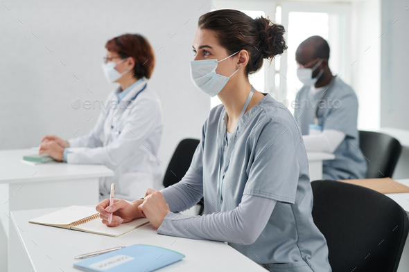 Medical students in masks sitting at training
