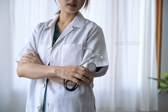 Female doctor in white uniform holding stethoscope in hand. Healthcare ...