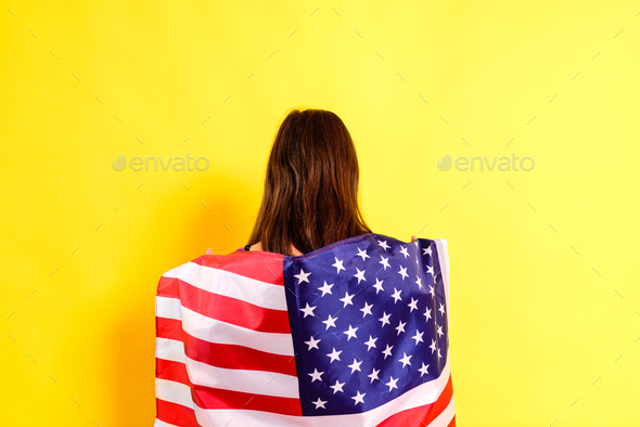 Young embarrassed woman covers herself with an American flag