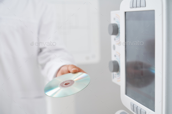 Doctor holding CD plate with results after ultrasound.