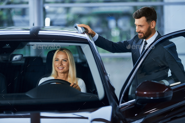 Woman choosing new car with help of salesman