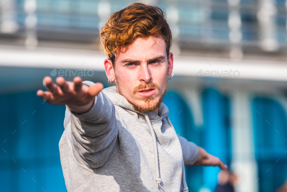 Young concentrated red-haired man practicing exercise  - Stock Photo - Images