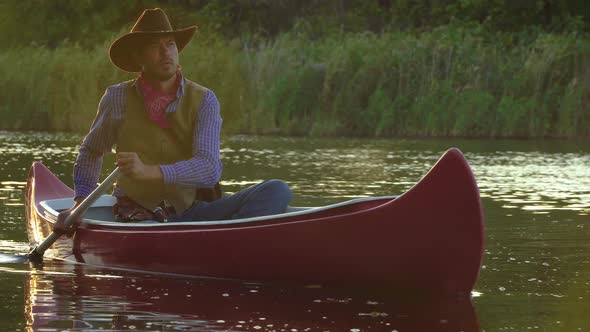 Cowboy in a Canoe Floats on the River alt