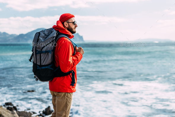 Tourist with a backpack on the background of the sea, rear view. - Stock Photo - Images