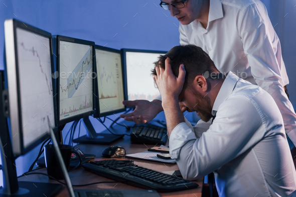 Bad luck, failure. Two stock traders working in the office with exchange technology
