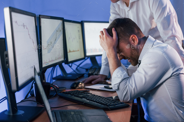 Bad luck, failure. Two stock traders working in the office with exchange technology