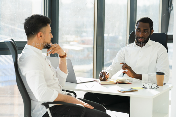Black man interviewing new employee in company office