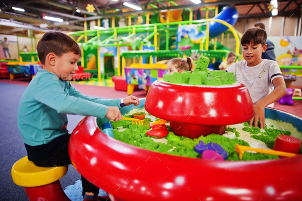 Kids play with kinetic sand in indoor play center.