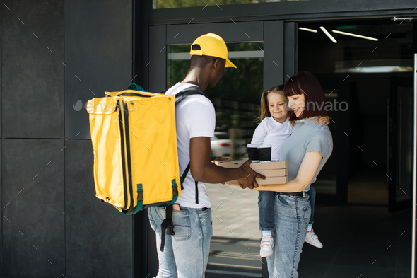 African young delivery man with yellow uniform and cap that new normal style by express service