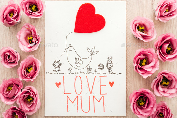top view of pink eustoma flowers and card with love mum words on wooden table